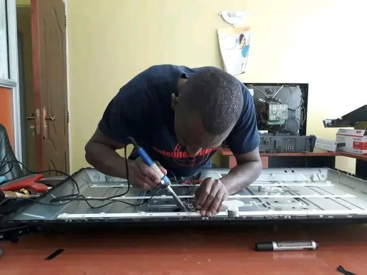 A photo of an electrician repairing a smart television